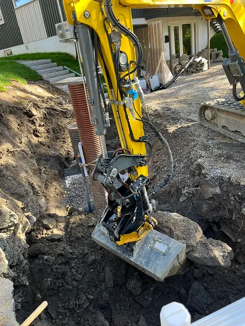 Gravemaskin utfører grunnarbeid ved rørinstallasjon